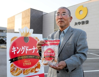 「キングドーナツ」を手にする丸中製菓の前社長、中山政幸さん＝加西市下宮木町