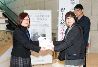 ５千人目の入館者になり、記念品を受け取る江島香さん（右から２人目）＝県立歴史博物館