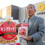 「キングドーナツ」を手にする丸中製菓の前社長、中山政幸さん＝加西市下宮木町