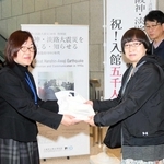 ５千人目の入館者になり、記念品を受け取る江島香さん（右から２人目）＝県立歴史博物館