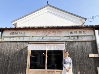 古民家カフェ「片岡家蔵　きなり」の店舗前で「ひょうごいいね！お店表彰」の大賞受賞を喜ぶ舘麻由さん＝姫路市網干区新在家