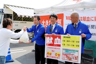 献血を終えた人に、返礼品を手渡す新聞販売店の店主たち＝姫路市飾磨区細江、イオンモール姫路リバーシティー