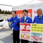 献血を終えた人に、返礼品を手渡す新聞販売店の店主たち＝姫路市飾磨区細江、イオンモール姫路リバーシティー