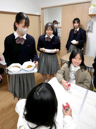 「子ども食堂」で配膳を手伝う網干高校の生徒（奥）ら＝姫路市網干区和久