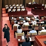 辞職勧告決議案の採決を前に退席する姫路市議会の高見千咲議員（左）＝３０日午前、姫路市役所