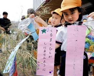 願いを込めた短冊をササにくくりつける子どもたち＝姫路市市之郷、姫路署