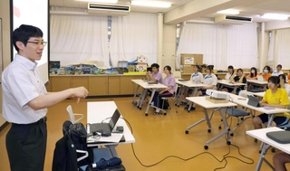 外務省職員の丸森隆史さん（左）の話に聞き入る生徒ら＝姫路飾西高校