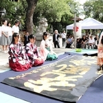 金色のカラー液で揮毫する高校生＝姫路護国神社
