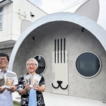 水産加工品の残渣を発酵させたペットフードを開発中の向井昭博社長（左）と安田明和さん。加工場の外観はネコの顔をかたどっている＝播磨海洋牧場