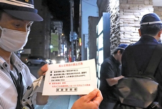 ビラを配り、客引き行為禁止を啓発する姫路署員ら＝姫路市塩町