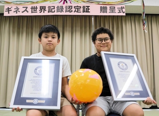 ギネス認定証を手に喜ぶダンミン・ヒウさん（左）とダオゴック・トゥさん＝姫路市花田町加納原田、東児童センター