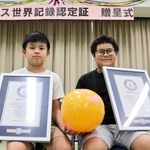 ギネス認定証を手に喜ぶダンミン・ヒウさん（左）とダオゴック・トゥさん＝姫路市花田町加納原田、東児童センター