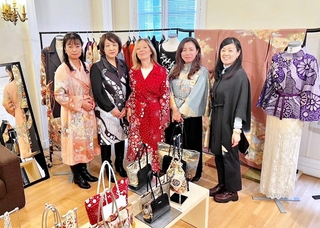 リメーク着物を着る仏ルモンド紙の記者を囲むサステナクチュール協会のメンバー＝パリ市内、同協会提供