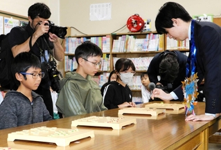 藤井聡太竜王（右）と対局する城陽小学校の児童たち＝２８日、姫路市北条