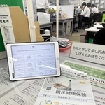 国民健康保険について外国人に配るチラシ（手前）と翻訳機になるタブレット端末＝姫路市役所