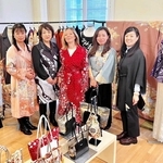 リメーク着物を着る仏ルモンド紙の記者を囲むサステナクチュール協会のメンバー＝パリ市内、同協会提供