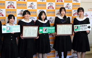 考案した標識と受け取った感謝状を手に持つ姫路工業高校デザイン科の生徒たち＝姫路市本町