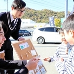 「お互いさまチケット」を子どもたちに手渡す東洋大付属姫路高校の生徒ら＝姫路市辻井３
