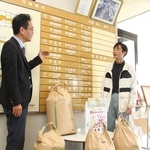 栽培した米を福崎町に贈った桜井俊治さん（右）＝福崎町役場