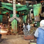 社員の説明を聞きながら、鎖の溶接工程を間近で見学する参加者＝姫路市網干区大江島、濱中製鎖工業網干工場