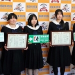 考案した標識と受け取った感謝状を手に持つ姫路工業高校デザイン科の生徒たち＝姫路市本町