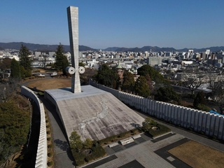 姫路のまち並みを見守るように立つ「太平洋戦全国戦災都市空爆死没者慰霊塔」＝姫路市西延末（ドローンで撮影・辰巳直之）