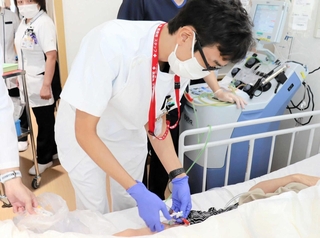 免疫細胞を取り出すため、患者の血液を採取する医師（姫路赤十字病院提供）