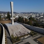 姫路のまち並みを見守るように立つ「太平洋戦全国戦災都市空爆死没者慰霊塔」＝姫路市西延末（ドローンで撮影・辰巳直之）