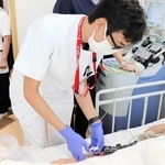 免疫細胞を取り出すため、患者の血液を採取する医師（姫路赤十字病院提供）