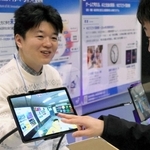 情報通信研究機構のブースで、宇宙天気予報センターの見学を模擬体験する参加者（右）＝アクリエひめじ