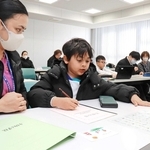 通訳のサポートを受けながら、日本語の初歩を学ぶ子どもたち＝姫路市北条口３