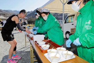 ランナーに手作りの豚汁を振る舞う地元住民ら＝姫路市夢前町塩田、塩田公民館