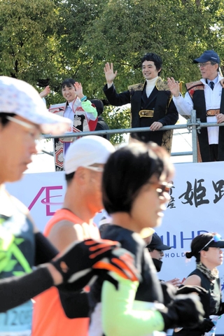 ランナーに手を振る池松壮亮さん＝姫路市本町
