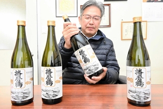 戦前に途絶えた「播磨鶴」を復活させた本田雄一郎さん。ラベルの文字は１２０年前の創業時と同じという＝姫路市網干区高田、本田商店