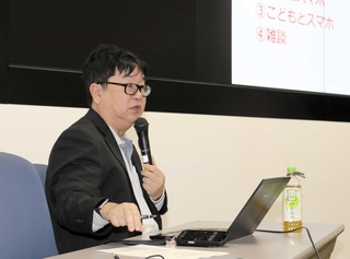 姫路市の小中高校生２万人に実施したスマートフォンの利用調査を報告する県立大の竹内和雄教授＝姫路市三左衛門堀西の町