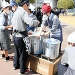 かまどに変身した防災ベンチで温めた豚汁をふるまう生徒ら＝姫路商業高校