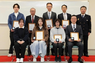 改発久樹消防局長（後列右端、当時）から表彰された人たちと阿部こころさん（前列左端）＝姫路市防災センター