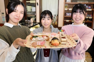 交通安全を啓発するケーキと、デザインを担当した兵庫県立大環境人間学部の学生たち＝姫路市飾東町庄、パティスリーペッシュ