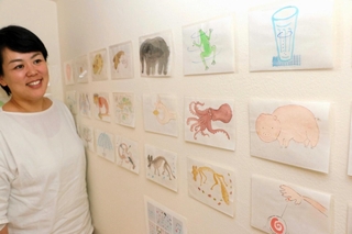 岩田健三郎さんが描いた言葉カード「ＣＡＲＤ　かあど」の原画を見つめる長女の愛子さん＝姫路市保城