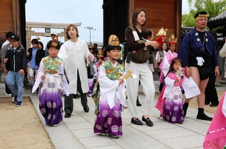 稚児衣装を着て境内を保護者らとともに歩く子どもたち＝大塩天満宮