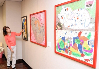 自作に込めた思いを語るもりたに千代さん。手前が、姫路市美術展で市長賞を受賞した「ステイ・ホーム」＝三木美術館