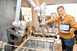 全自動でそうめんをゆでるロボットを紹介するイトデンエンジニアリングの杉田真悟さん＝姫路市呉服町