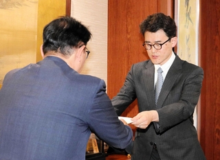 給与改定の答申書を清元秀泰市長（左）に手渡す兵庫県立大学の井関崇博教授＝姫路市役所