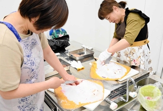 アカエイに包丁を入れ、解体を体験する参加者＝姫路市白浜町
