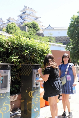 姫路城に設置された給水機を使う外国人観光客＝姫路市本町