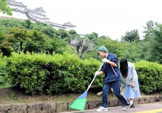姫路城周辺の落ち葉などを拾い集める姫路北高校の１年生たち＝姫路市本町