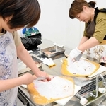 アカエイに包丁を入れ、解体を体験する参加者＝姫路市白浜町