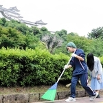 姫路城周辺の落ち葉などを拾い集める姫路北高校の１年生たち＝姫路市本町