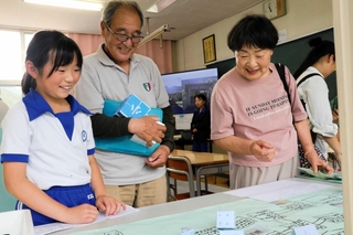 手作りしたすごろくで地域住民と交流する安富北小学校の児童（左）＝姫路市安富町杤原