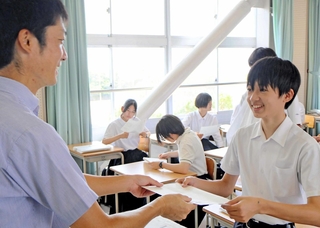 担任から通知表を受け取る姫路市立高生＝姫路市辻井９
